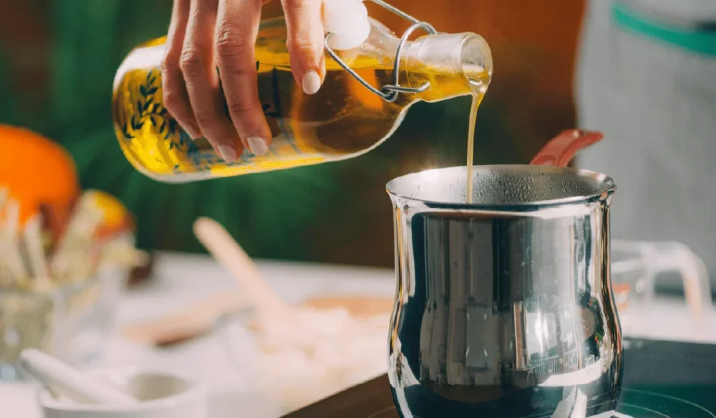 Persona añadiendo aceite de sésamo desde una botella a un cuenco.