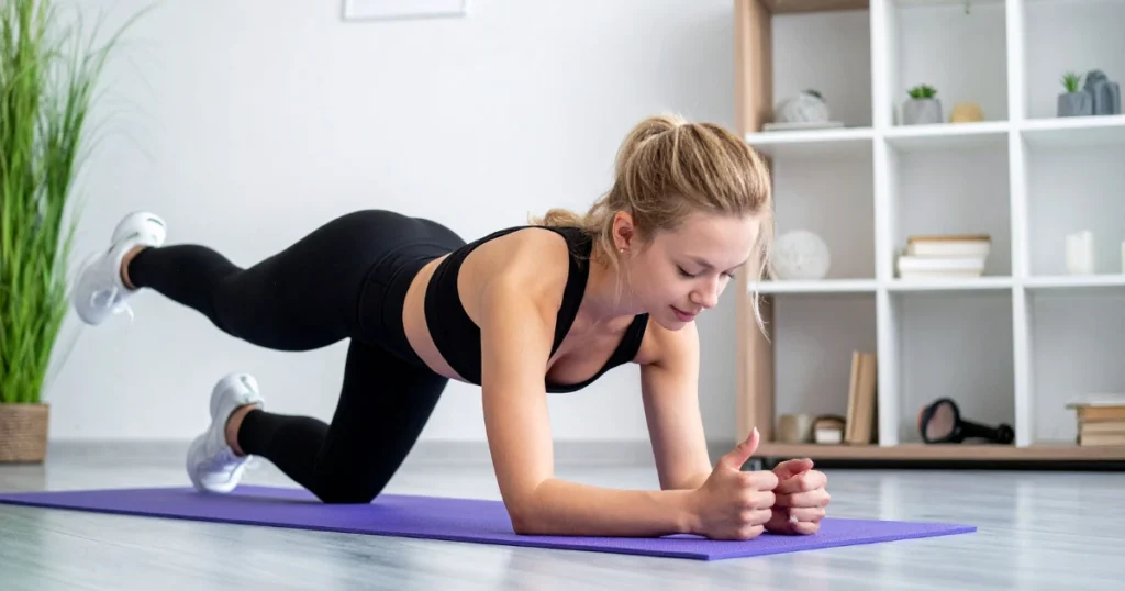 Mujer haciendo deporte en posición de plancha tras la ingesta de suplementos deportivos naturales.
