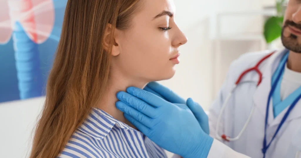 Doctor auscultando a paciente en zona del cuello donde se ubican las glándulas tiroideas.