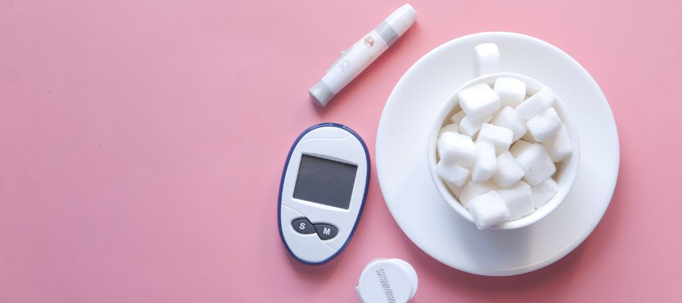 Azúcar de abedul sobre una taza y un medidor del azúcar e insulina para hablar sobre el mejor edulcorante para diabéticos junto a Distribuciones Ballester