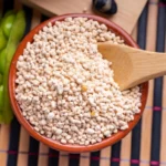 Cuenco con muchas semillas de gomasio y una cuchara para servir.