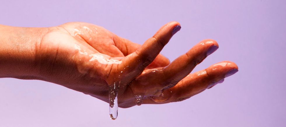 una mano lubrica con lubricantes naturales de cosmética sexual